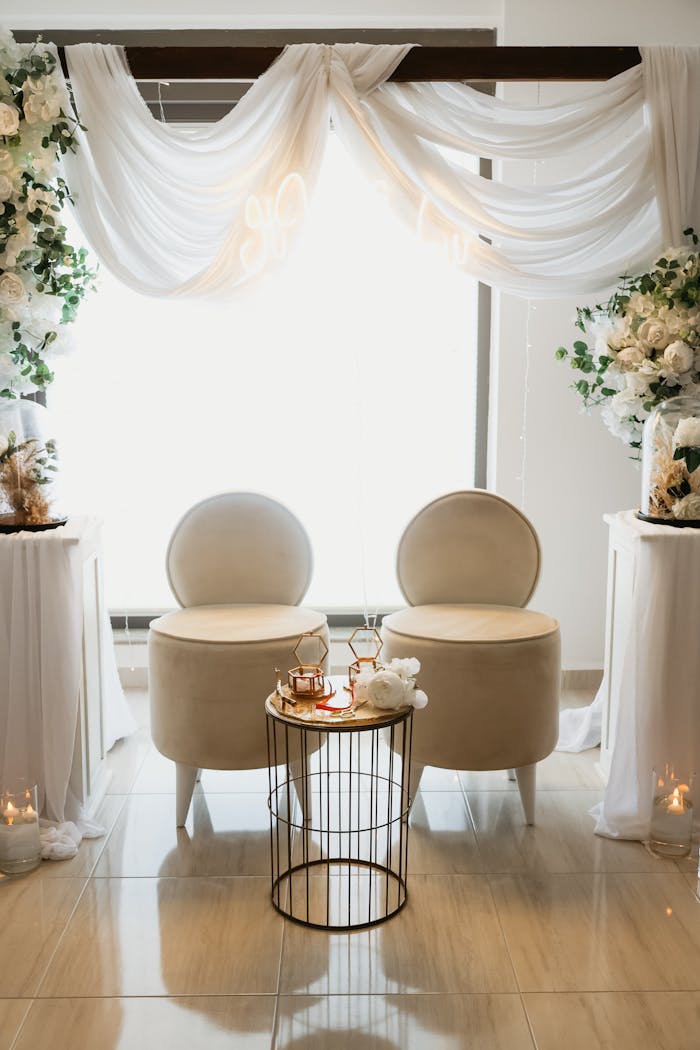 Services Beautifully decorated seating area for an engagement ceremony with luxurious chairs and floral decor.